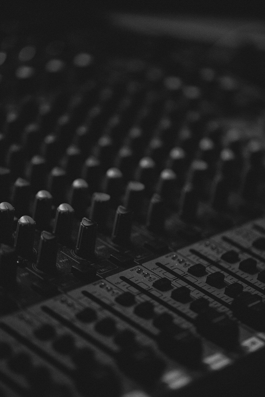 Professional audio mixing console with equalizer sliders and knobs